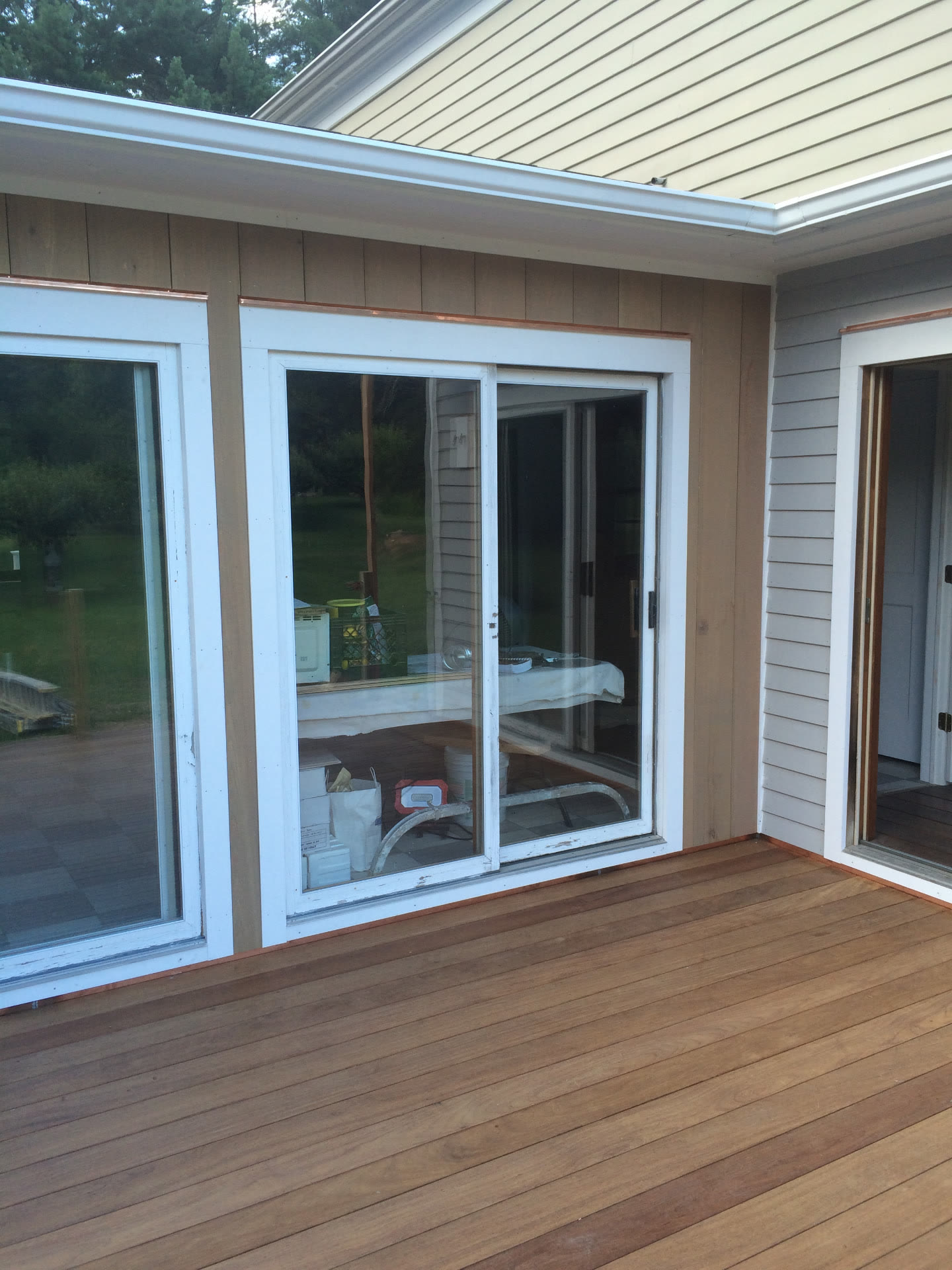 New hardwood deck with copper flashing tape protecting the trim around sliding doors