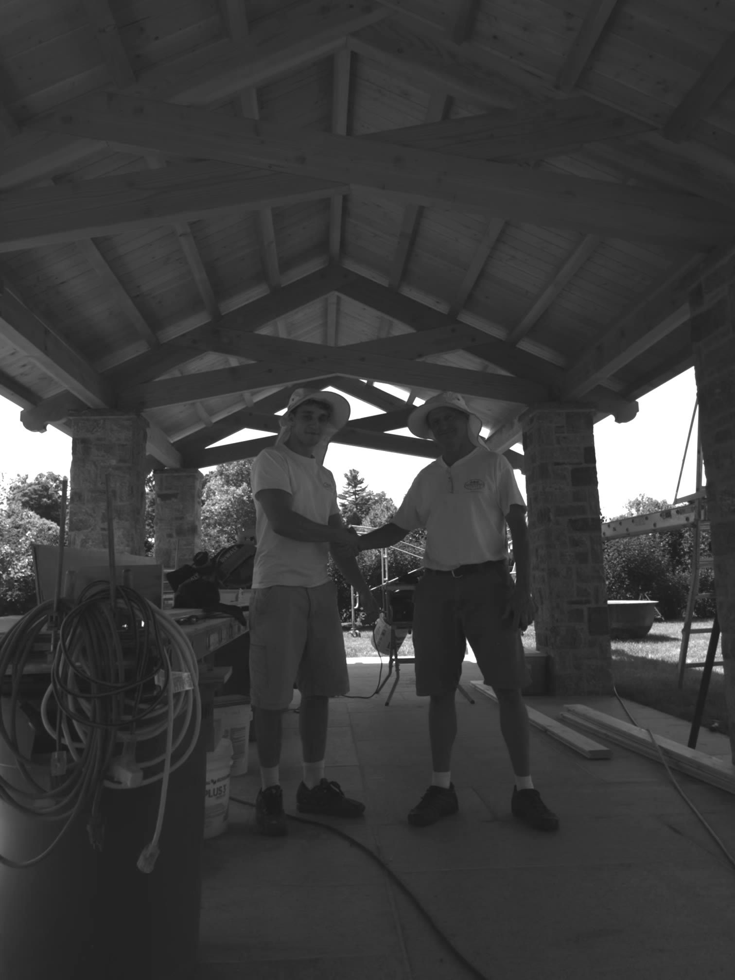 Dmitri Logvinski and his son Sava standing beneath a timber pavilion they built together